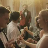 Para młoda tańczy na weselu, jak w filmach Wojciecha Smarzowskiego. W tle wodzirej z mikrofonem.