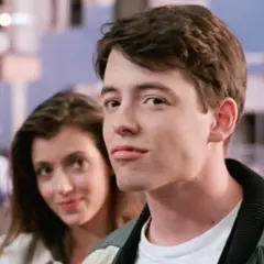 Matthew Broderick w jednym z kultowych matthew broderick filmów, uśmiecha się do kamery, podczas gdy za nim widać kobietę.