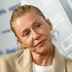 Katarzyna Warnke w beżowym płaszczu, z włosami upiętymi do tyłu. Aktorka znana z wielu polskich filmów.