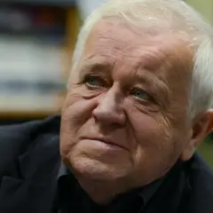 Marian Dziędziel, znany z wielu niezapomnianych ról w polskich filmach, zamyślony w czarnym garniturze.