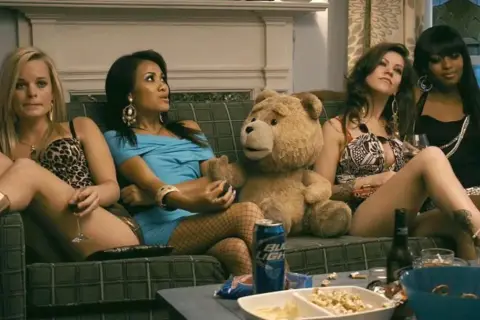 Ted 3: pluszowy miś i cztery kobiety siedzą na kanapie, pijąc i jedząc przekąski.
