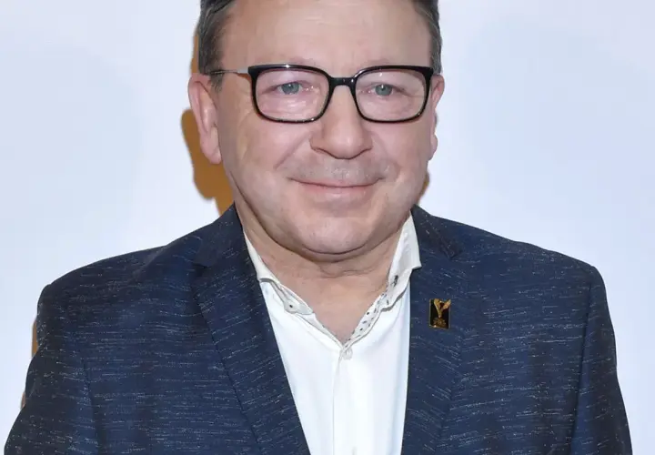 Zbigniew Zamachowski w garniturze i okularach, znany z wielu polskich filmów.