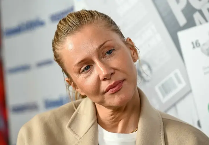 Katarzyna Warnke w beżowym płaszczu, z włosami upiętymi do tyłu. Aktorka znana z wielu polskich filmów.