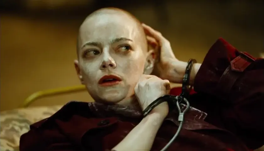Emma Stone w kajdankach, z ogoloną głową i makijażem, jak w filmach Yorgosa Lanthimosa.