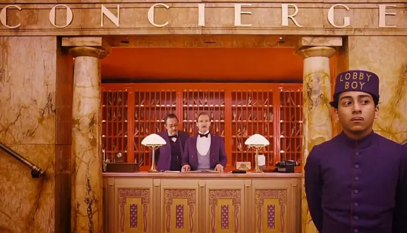 Lobby boy i dwaj recepcjoniści w hotelu, jak z filmów Wesa Andersona.