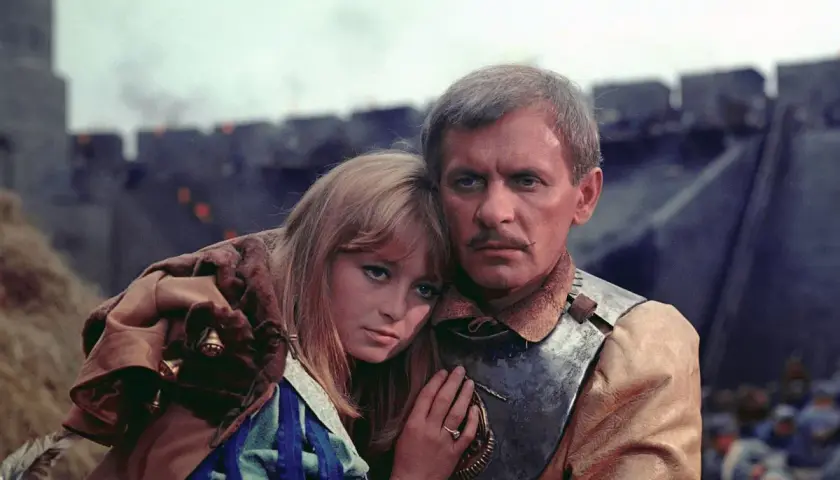 Magdalena Zawadzka w filmach, tu w scenie z rycerzem na tle oblężonego zamku.