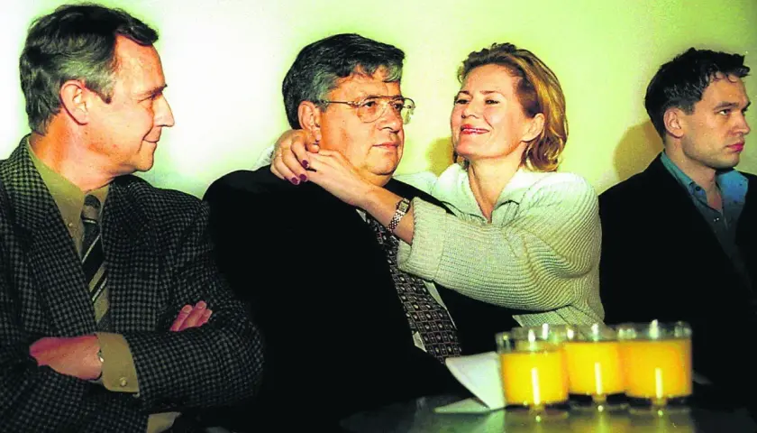 Lew Rywin, otoczony przez ludzi, z kobietą obejmującą go czule.