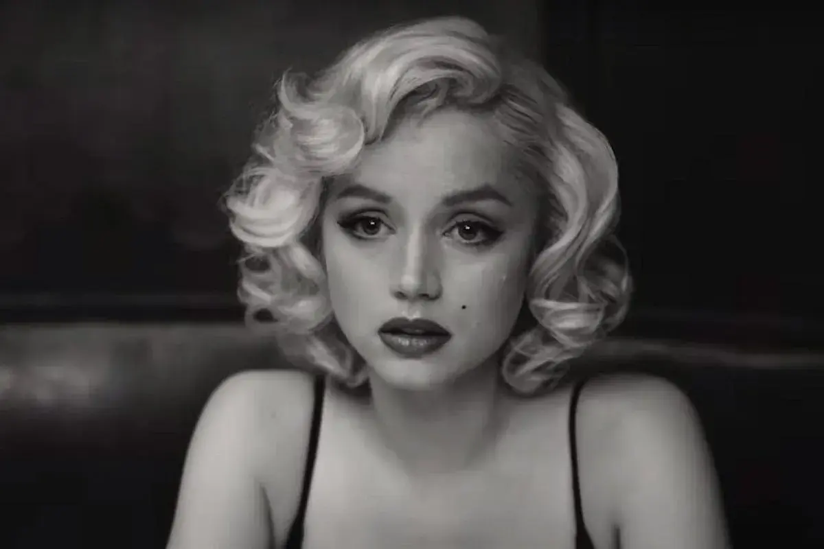Kobieta w stylu Marilyn Monroe, z charakterystyczną fryzurą i makijażem, przypomina ikony z jej filmów.