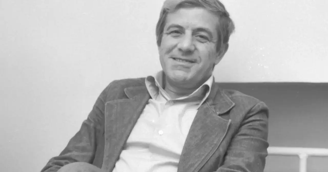 Uśmiechnięty Zbigniew Zapasiewicz, ikona polskiego kina, w eleganckim stroju. Jego niezapomniane role w licznych filmach na zawsze zapisały się w historii.