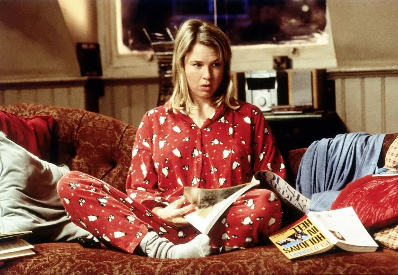 Renée Zellweger w piżamie z pingwinami, czytająca książkę 
