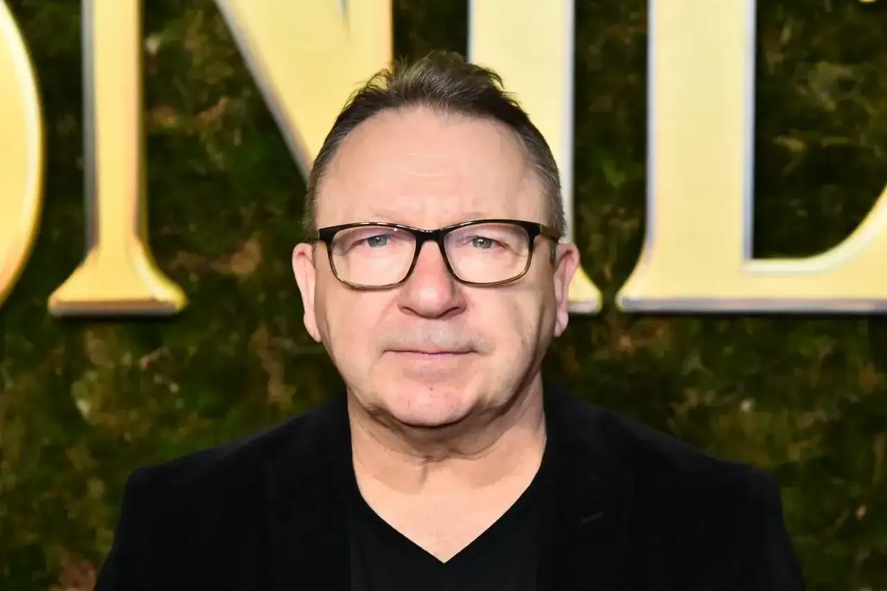 Zbigniew Zamachowski, znany z wielu polskich filmów, w czarnym stroju i okularach.