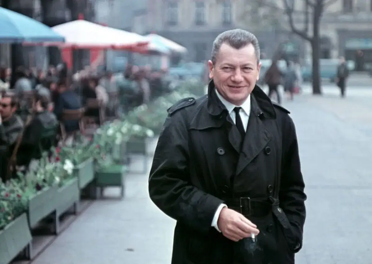 Wojciech Jerzy Has, w czarnym płaszczu, pali papierosa na tle kawiarni. Jego filmy to klasyka polskiego kina.
