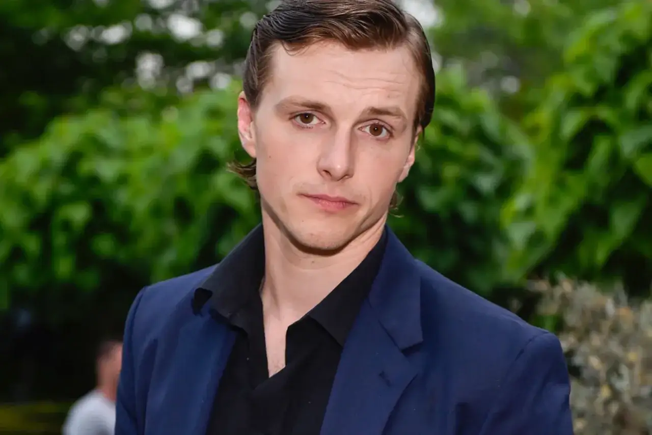 Tomasz Włosok, znany z filmów, w granatowej marynarce i czarnej koszuli.