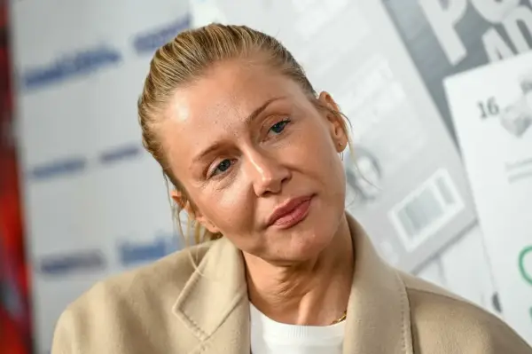Katarzyna Warnke w beżowym płaszczu, z włosami upiętymi do tyłu. Aktorka znana z wielu polskich filmów.